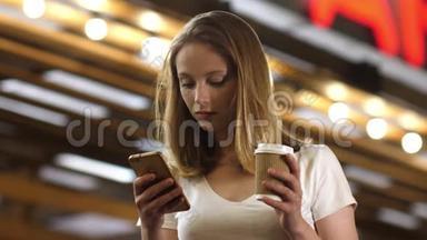 <strong>忙着</strong>用手机发短信喝咖啡的年轻女子。