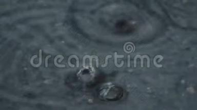 雨中路面上的水坑.. 水滴掉进水里。
