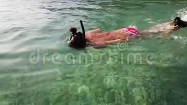 青少年在清澈的海水中戴面具和脚蹼浮潜