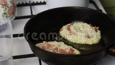 女人用碎肉炸煎饼。 土豆泥和肉末放在热锅里。 厨师用捣碎的肉盖上肉末