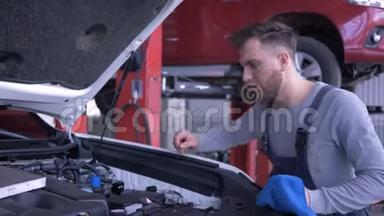 汽车服务，有吸引力的技术人员在汽车修理期间用敞篷汽车车间检查油位，微笑