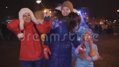 圣诞节前夕，母亲和女儿在城镇广场玩得很开心。