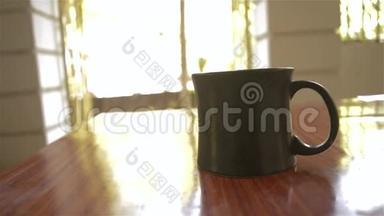 卡布奇诺香气咖啡杯<strong>早餐</strong>在咖啡馆的木制桌子背景。 <strong>早晨</strong>的<strong>阳光</strong>从窗户照射进来。 复制空间