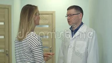男医生在医院大厅里与年轻女子交谈