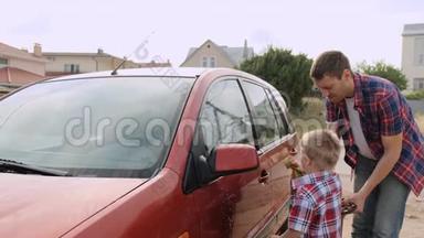 一个金发的小男孩，<strong>我在</strong>他年轻父亲的监护下洗`车前灯，慢动作