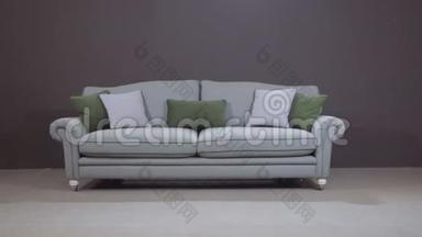 最简约的灰色沙发，带有天然填充物的绿色装饰枕头