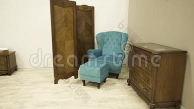 蓝色时尚椅子与搁脚凳木制屏幕和抽屉的胸部坚实的橡木。