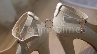 结婚戒指在女人`白鞋上。 新娘白鞋上漂亮`结婚戒指。 白色婚礼订婚