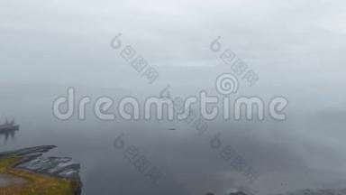 从江口<strong>浓</strong>雾</strong>的高空俯瞰，岸边有一座黑山和一座码头