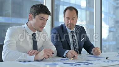 两名商务人员在会议室工作项目文件