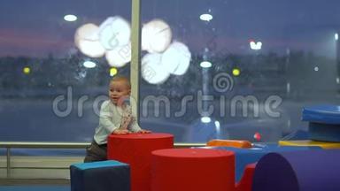 在机场的一个儿童游乐区，微笑着`可爱的男孩在玩大方块
