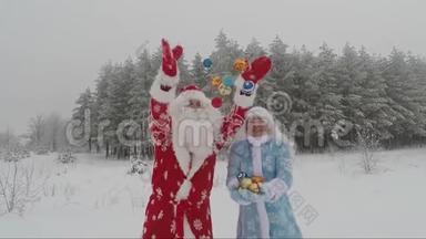 快乐的圣诞老人和年轻的女孩在冬天的森林里投掷彩色圣诞球玩得很开心。 新年