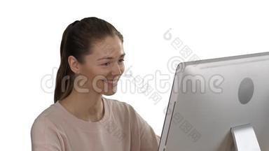 学生金发女孩看着<strong>电脑显示</strong>器，在白色背景上微笑。