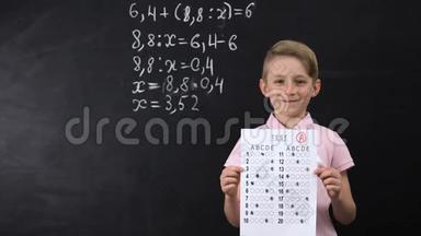 微笑的小学生表现出出色的测试，数学练习写在后面