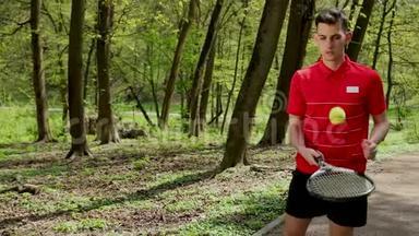 人从球拍中<strong>击打</strong>网球。 年轻人打网球。 穿着红色T恤和黑色衣服的人
