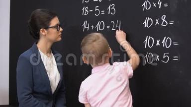 聪明的小学生在黑板上解决数学练习，老师站在附近