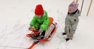 穿着冬装的可爱的孩子们一<strong>起坐</strong>着雪橇