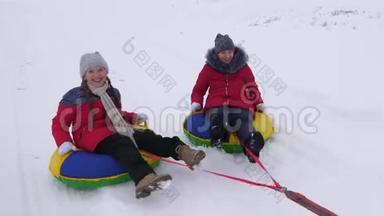 孩子们在冬天雪橇。 青少年在冬季公园玩圣诞假期。 快乐童年的概念。 开心快乐
