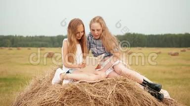 十几岁的女孩在度假时在乡下的<strong>干草</strong>堆<strong>上</strong>看书。 令人惊讶的女孩在<strong>干草</strong>堆<strong>上</strong>看书