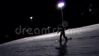 年轻的女滑雪运动员自信地沿着<strong>赛道</strong>灯光赛车。 晚上在滑雪场骑马。