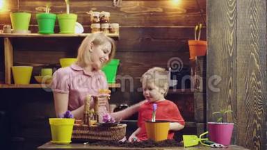 母亲`儿子的爱。 母亲教儿子园艺. 母亲和儿子正在花盆里种花。 家庭