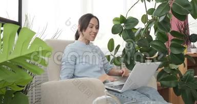 女人一边欢呼一边视频聊天笔记本电脑