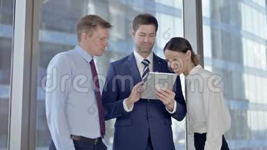 在会议室使用平板电脑和微笑的开朗的执行商务人员