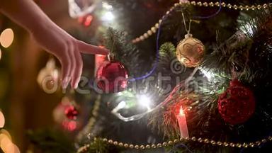 孩子们`手在圣诞树上挂一个球装饰。