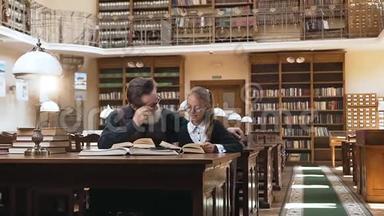 聚精会神的长胡子老人戴着眼镜，坐在图书馆的桌子旁，听着他那可爱的少年怎么读