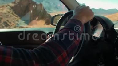 不认识的人穿着格子衬衫开车。 在<strong>火山岛</strong>的沙漠外。 山脉和石崖