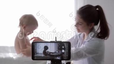 博客，流行的vlogger女医生在婴儿体检期间为智能手机上的vlog拍摄新一集