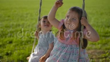 两个女孩的脸在一个田里摆动在一个绳索摆动特写