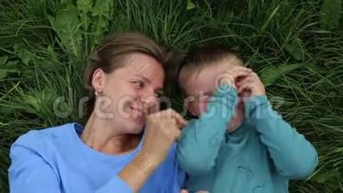 母亲和儿子躺在草地上，玩得很<strong>开心</strong>，笑得很<strong>开心</strong>