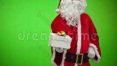 圣诞老人戴着手套，手里拿着礼品盒。 绿色背景。 快关门。 正面视图