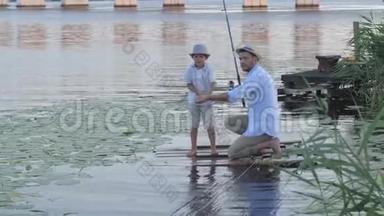家庭周末，父亲和他的小儿子在靠近水的码头上钓鱼后，沿着木板<strong>上岸</strong>