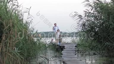 孩子们的假期，小可爱的男孩和他的爸爸一起钓鱼回来了，快乐和快乐，因为丰富的捕获。