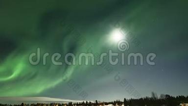 在瑞典冰冻的湖泊和冬季景观上闪耀着灿烂的绿色极光的视频，来自满月和北方的光线