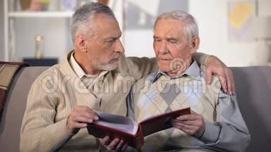 老父亲和太阳在家里沙发上看家庭相册，在一起，特写