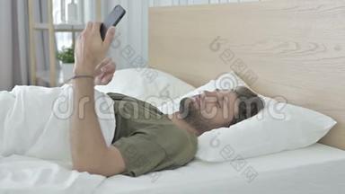 年轻人在床上翻动手机