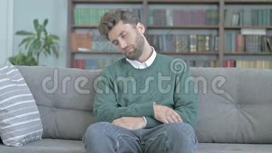 疲惫的年轻人坐在沙发上小睡片刻