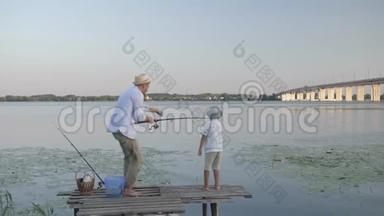 暑假在河边闲逛，戴着草帽的快乐父子把鱼从水里拉出来