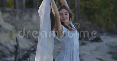 漂亮的白人女人站在森林里，戴着被风吹过的浅白色围巾，微笑着。 漂亮姑娘<strong>花钱</strong>
