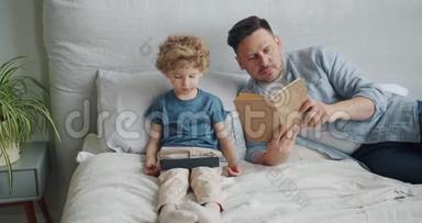 严肃的家伙在床上看书，而<strong>小孩</strong>子在平板电脑上看<strong>动画</strong>片
