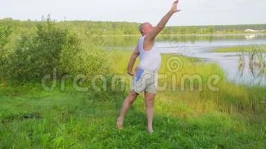 一位中年男子早上在湖边做呼吸练习瑜伽