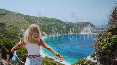 在希腊的凯法洛尼亚岛，美丽的金发女人在暑假举起太阳帽。 <strong>幸福生活</strong>