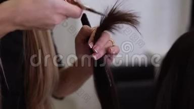 熟练的法国美甲美发师的特写，用<strong>新</strong>的金属剪刀剪下<strong>客</strong>户棕色的头发。 <strong>专</strong>业人员