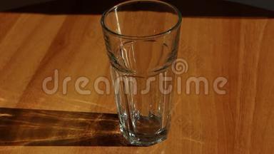 水从玻璃壶中倒入透明的玻璃杯