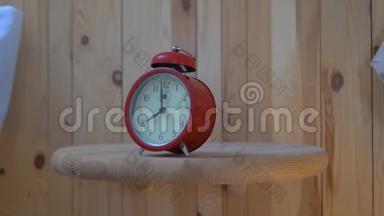 早晨，一个红色复古风格的闹钟响起.. 男人`手拿闹钟