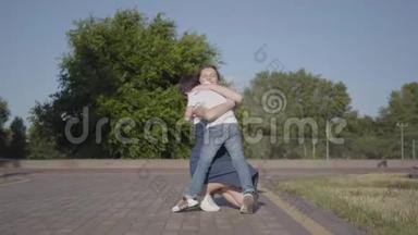小男孩<strong>跑到</strong>他姐姐身边，在夏天的公园里拥抱她。 户外休闲。 之间的友好关系