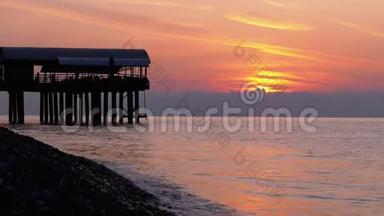 全景的夕阳越过海面旁边的码头剪影..